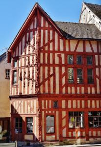 een groot houten gebouw met een rode bij Appartement 30m² RDC 2 pièces in Joigny