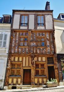 een oud houten gebouw met ramen aan een straat bij Appartement 30m² RDC 2 pièces in Joigny