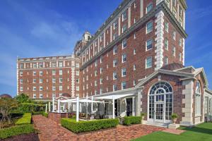 a large red brick building with a courtyard at The Historic Cavalier Hotel and Beach Club Autograph Collection in Virginia Beach