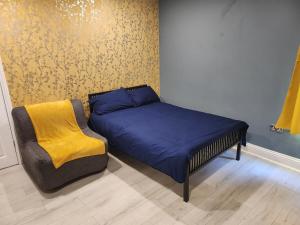 uma cama e uma cadeira num quarto em Dodi Apartment em Londres