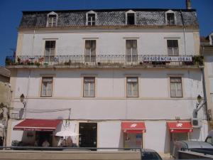 Un gran edificio blanco con un cartel en él. en Residência Ideal, en Coímbra