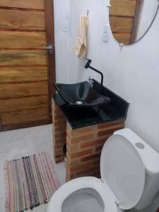 a bathroom with a white toilet and a sink at Chale 8A in Cunha +28 photos