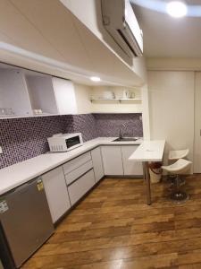 a kitchen with white cabinets and a table and a sink at Rajhans Belliza , Hotel apartment units in Surat