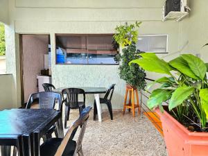 a patio with tables and chairs and plants at Apt Centro de Foz para até 8 pessoas in Foz do Iguaçu