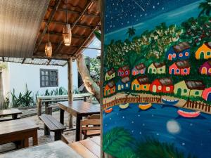 um mural num restaurante com mesas e bancos em Pousada Zen Caraiva em Caraíva