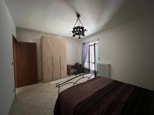 1 dormitorio con cama y lámpara de araña en Il Vicolo en Revello