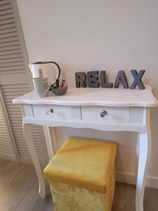 a white desk with a relax sign and a stool at Elise cornu in Mantry