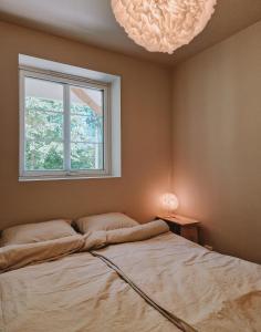 a bedroom with a bed and a window and lights at Cozy and newly renovated appartment in Kristiansand