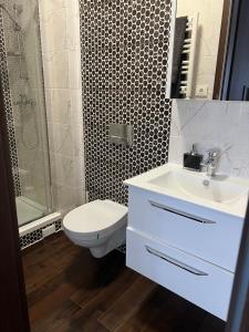 ein Badezimmer mit einem weißen Waschbecken und einem WC in der Unterkunft ŽALI apartamentai Šilutė in Šilutė