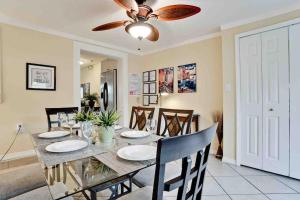 a dining room with a table and a ceiling fan at Venice Island Private Pool Home Wows! Beach! Po in Venice