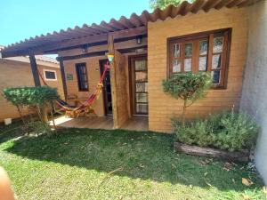 een huis met een hangmat ervoor bij Chalés do Alcantilado in Santo Antônio do Pinhal