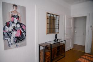 een woonkamer met een schilderij aan de muur en een tafel bij Christophe in Basse-Yutz