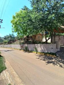 a house on the side of a road with a tree at Chalés do Alcantilado in Santo Antônio do Pinhal