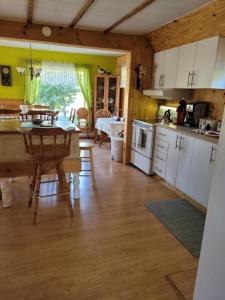 a kitchen and dining room with a table and a dining room at Le Gîte Du Gardien Blanc in Saint-David-de-Falardeau