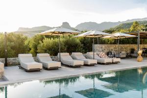 a swimming pool with lounge chairs and umbrellas next to a pool at Beach Villas in Crete - Alope & Ava member of Pelagaios Villas in Ierapetra