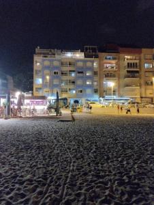 a beach at night with buildings in the background at Palacio del mar in Torrevieja