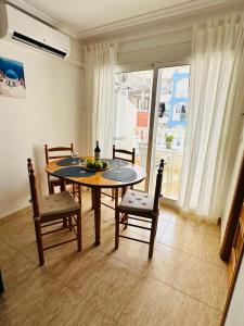 a dining room with a table and chairs and a window at Palacio del mar in Torrevieja +12 photos