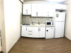 a kitchen with white cabinets and a sink and a refrigerator at Апартаменты для семьи (№4) in Yalova