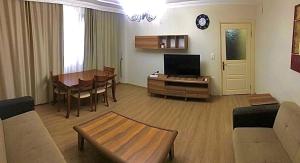 uma sala de estar com um sofá, uma mesa e uma televisão em Апартаменты для семьи (№4) em Yalova