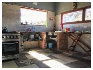 a kitchen with a sink and a stove and a window at Cabaña San Roque in Humahuaca
