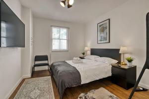 een slaapkamer met een bed, een stoel en een televisie bij Apartment in Shoreditch/ Old St in Londen