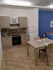 eine Küche mit einem Holztisch sowie einem Tisch und Stühlen in der Unterkunft Casa dell’Assunta in Trani