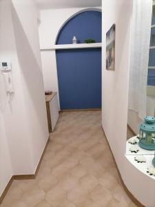 a hallway with a blue door and a tile floor at Casa dell’Assunta in Trani