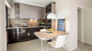 a kitchen with a table and white chairs in a room at Biloba Garden in Wengern