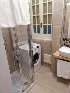 ein Badezimmer mit einer Waschmaschine und einem Waschbecken in der Unterkunft Casa dell’Assunta in Trani