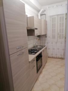 una cucina bianca con piano cottura e lavandino di Casa dell’Assunta a Trani