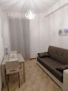 ein Wohnzimmer mit einem Sofa und einem Tisch in der Unterkunft Casa dell’Assunta in Trani