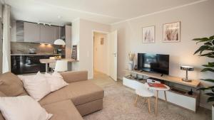 a living room with a couch and a tv at Biloba Garden in Wengern