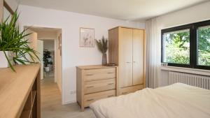a bedroom with a bed and a dresser and a window at Biloba Garden in Wengern