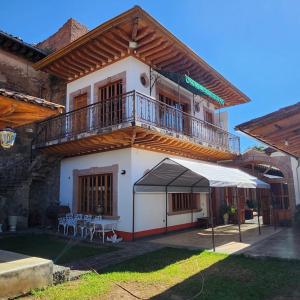 a building with a balcony and a table and chairs at La Casa Baez in Pátzcuaro