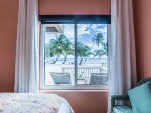 a bedroom with a window with a view of the beach at Sapphire Beach Resort in Basil Jones +116 photos