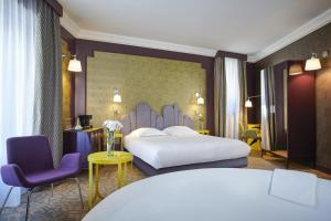 a bedroom with a large bed and purple chairs at Grand Hôtel du Midi Montpellier - Opéra Comédie in Montpellier +37 photos