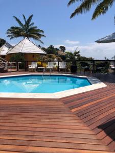 a large swimming pool with a wooden deck next to it at Hotel Morro De São Paulo in Morro de São Paulo