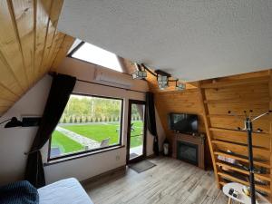 una vista interior de una casa pequeña con una ventana grande en Căsuțele de sub pădure en Avrig