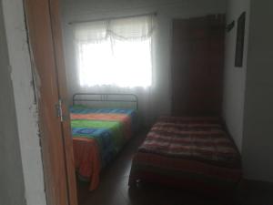Cette petite chambre comprend 2 lits et une fenêtre. dans l'établissement Quiero finquear, à Manizales