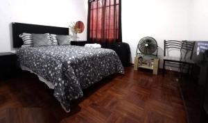 1 dormitorio con 1 cama con edredón blanco y negro en Casa Valle Encantado, en Lima