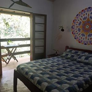a bedroom with a bed and a large window at Pousada Portal Floresta Paraty in Paraty