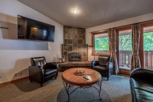 een woonkamer met stoelen, een tafel en een open haard bij Solstice Suites in Leavenworth