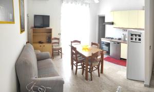 ein Wohnzimmer mit einem Sofa und einem Tisch sowie eine Küche in der Unterkunft Casa Alea - Appartamento turistico - Paola- in Paola