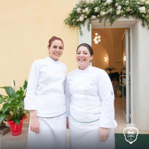 dos mujeres con uniformes blancos parados una al lado de la otra en Villa Euchelia, en Castrocielo