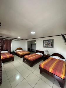 a hotel room with three beds in it at Brillasol Airport Hotel in Alajuela