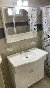 y baño con lavabo blanco y espejo. en Departamentos San Lorenzo en Tres Arroyos