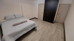 1 dormitorio con 1 cama y armario negro en AlojaT Dept 2 Urdesa Norte, en Guayaquil