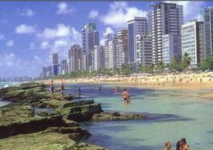 una playa con gente en el agua y una ciudad en Betel Beach Flat Internacional Boa Viagem, en Recife