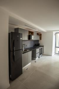 - une cuisine avec un réfrigérateur noir dans la chambre dans l'établissement 54 Diseño Urbano, à Ushuaia