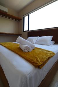 a bed with two towels on it with a window at Akbal Tulum in Tulum